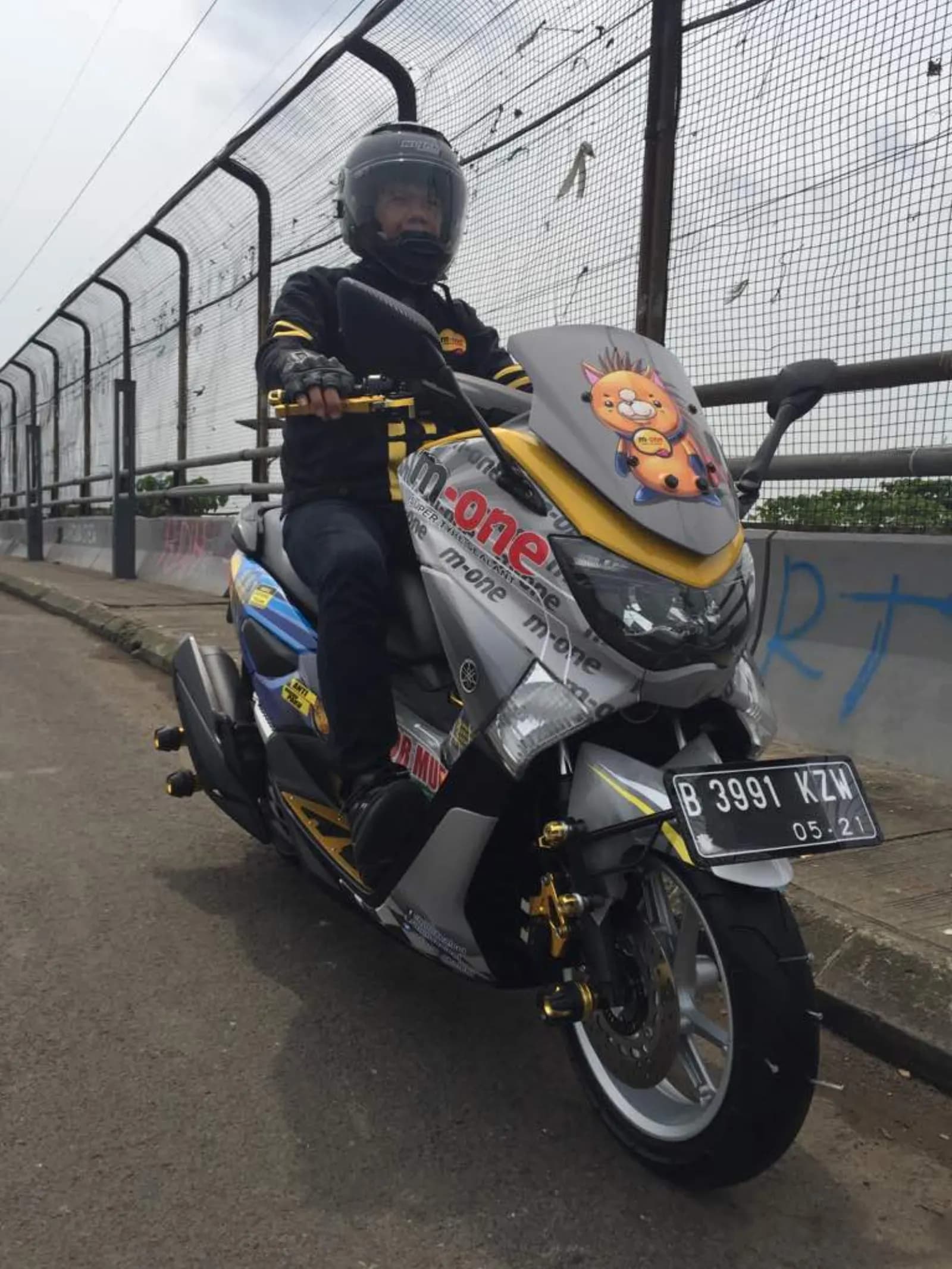 Pengendara N-Max dengan stiker M-1 pada sepeda motor